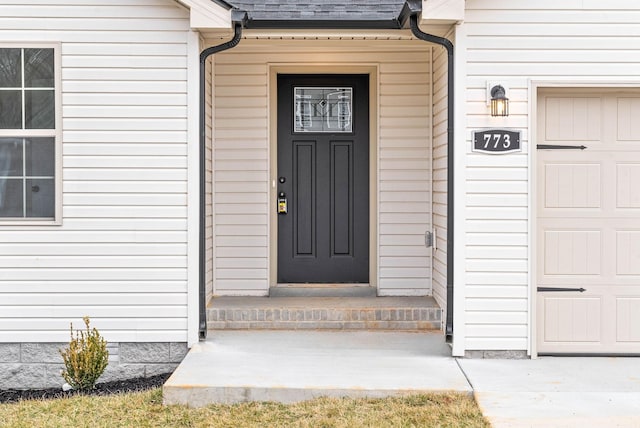 view of exterior entry featuring a shingled roof