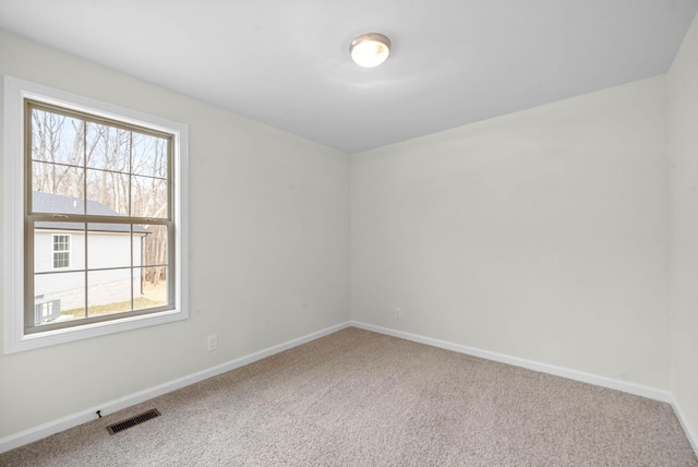 carpeted empty room with visible vents and baseboards