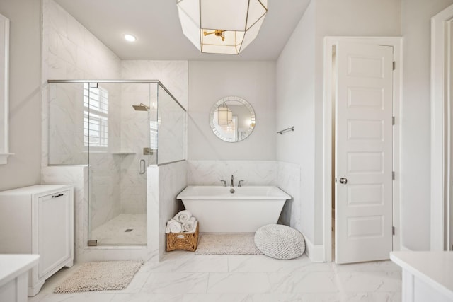 full bath with marble finish floor, a shower stall, a freestanding tub, and vanity