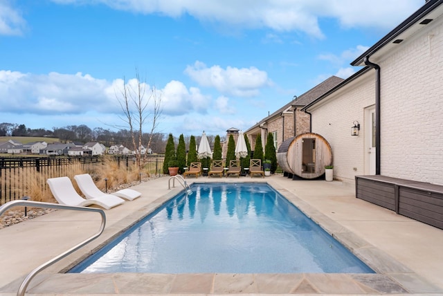 view of swimming pool featuring a fenced in pool, a residential view, fence, and a patio