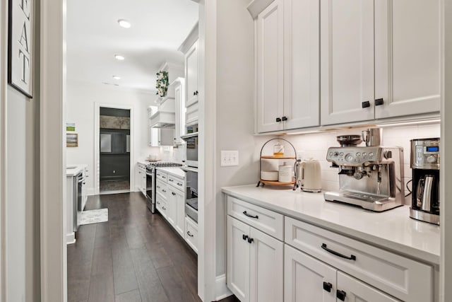 kitchen with decorative backsplash, white cabinetry, stainless steel appliances, and light countertops