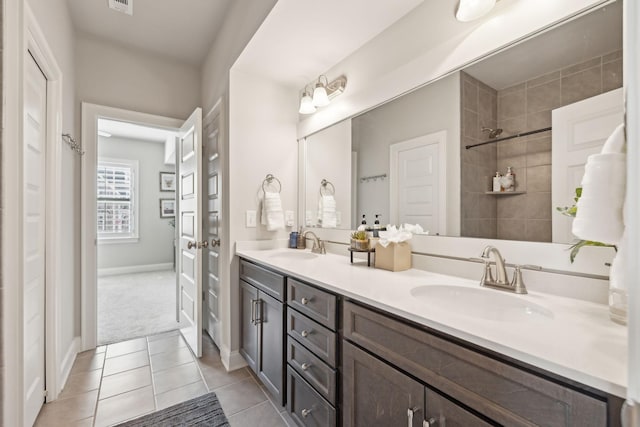 bathroom with double vanity, a sink, visible vents, and tile patterned floors