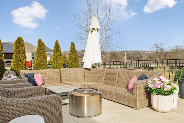 view of patio / terrace with fence and an outdoor living space with a fire pit