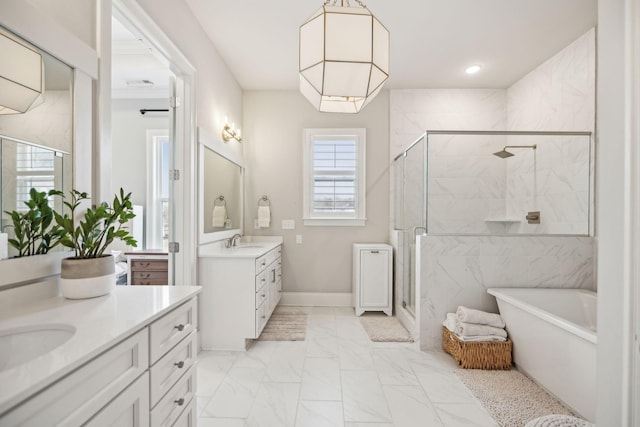 bathroom featuring a sink, marble finish floor, a freestanding tub, a shower stall, and two vanities