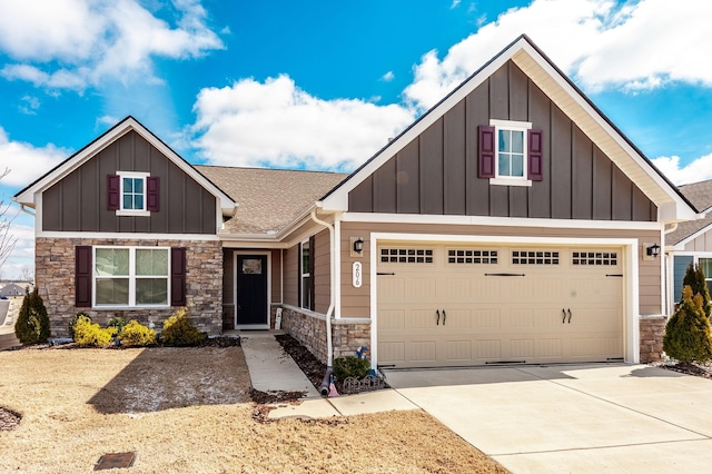 craftsman-style house featuring driveway, stone siding, and board and batten siding