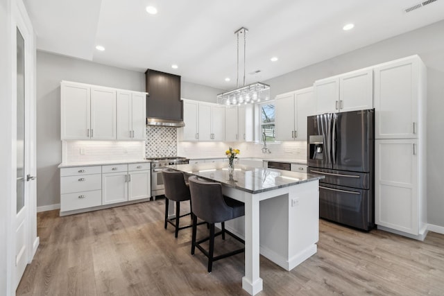 7609 Nolensville Rd, Nolensville, TN 37135 - kitchen with white cabinets, appliances with stainless steel finishes, a breakfast bar area, a center island, and custom exhaust hood