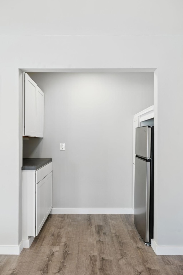 7609 Nolensville Rd, Nolensville, TN 37135 - kitchen featuring light wood finished floors, dark countertops, freestanding refrigerator, white cabinetry, and baseboards