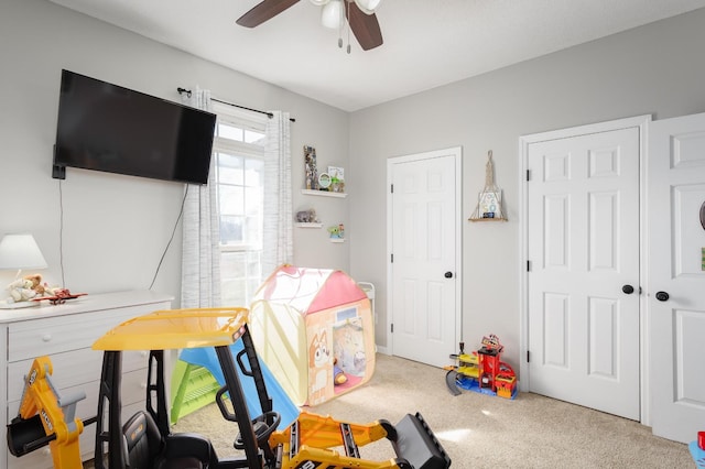 game room with a ceiling fan and carpet flooring