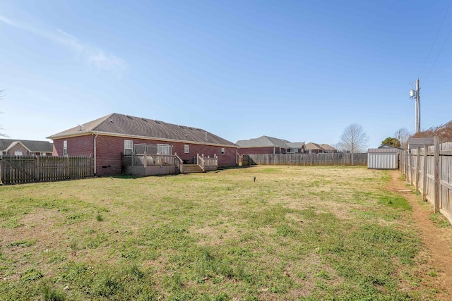 view of yard featuring a storage shed, an outdoor structure, and a fenced backyard