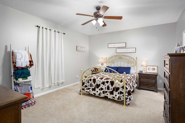 bedroom featuring light colored carpet, ceiling fan, a textured ceiling, and baseboards