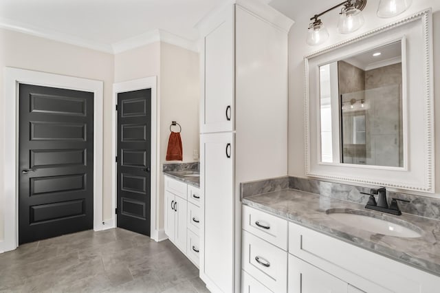 full bathroom with a stall shower, two vanities, a sink, and crown molding