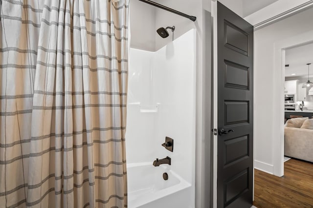 full bathroom with shower / bathtub combination with curtain and wood finished floors