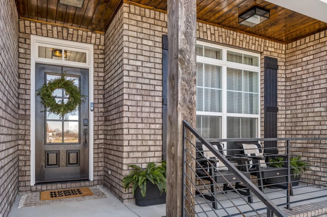 view of exterior entry featuring brick siding