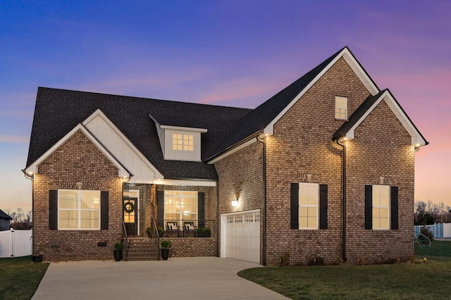 traditional home with a garage, a yard, concrete driveway, and brick siding