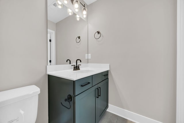 half bath featuring toilet, baseboards, and vanity