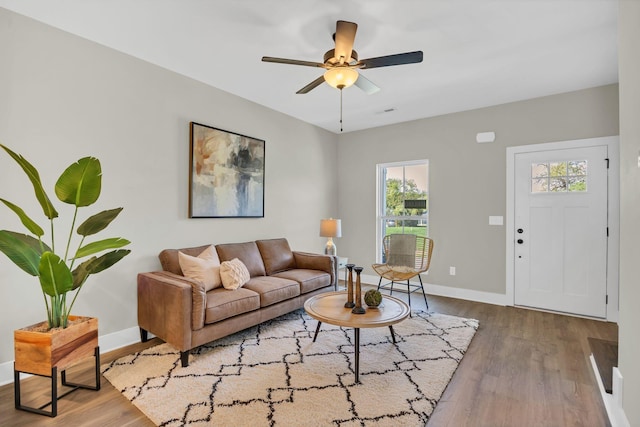 living area with ceiling fan, baseboards, and wood finished floors