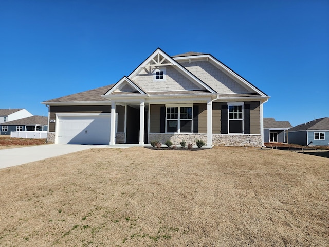 craftsman house featuring a garage, stone siding, concrete driveway, and a front yard