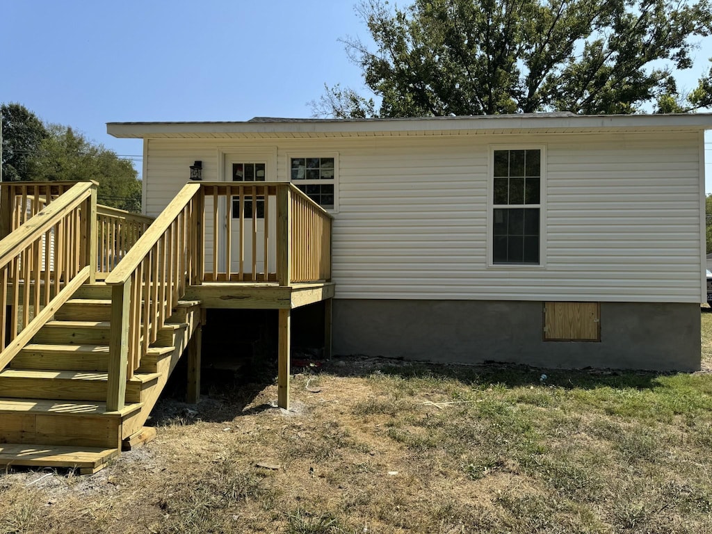 rear view of property featuring stairs and a deck