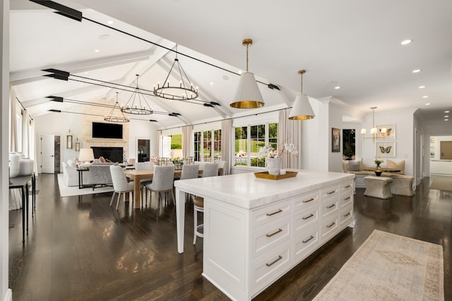 313 Deerwood Ln, Brentwood, TN 37027 - kitchen featuring open floor plan, a chandelier, a large fireplace, white cabinetry, and hanging light fixtures