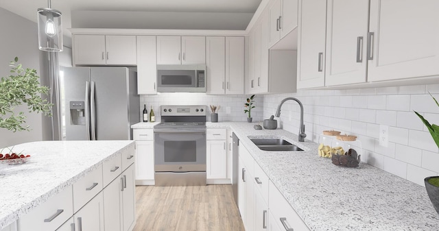 kitchen featuring stainless steel appliances, a sink, light wood-style floors, white cabinets, and pendant lighting