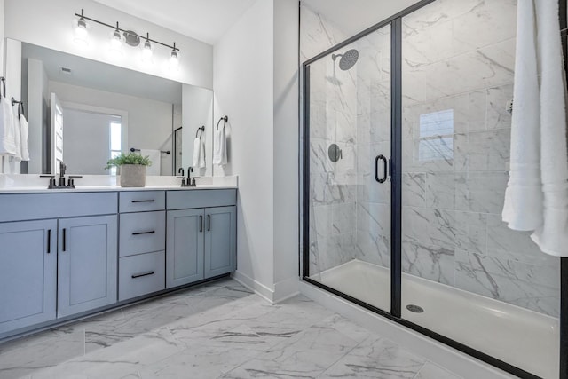 bathroom featuring marble finish floor, a sink, a marble finish shower, and double vanity