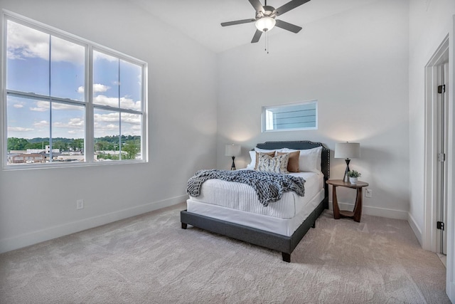 bedroom featuring ceiling fan, baseboards, and light colored carpet