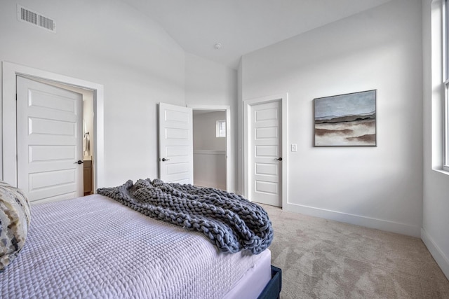 bedroom featuring lofted ceiling, visible vents, light carpet, and baseboards