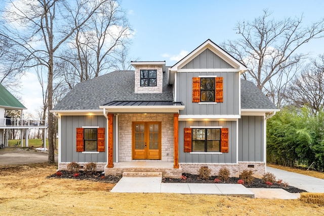 modern farmhouse style home with roof with shingles, a porch, board and batten siding, and crawl space