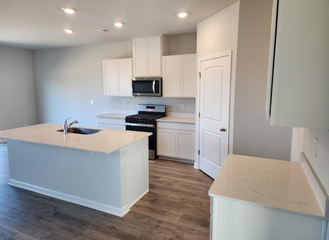 kitchen with white cabinets, a kitchen island with sink, stainless steel appliances, and a sink