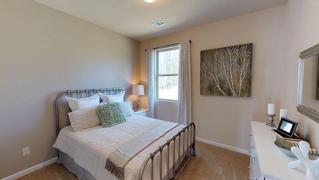 bedroom with light carpet, visible vents, and baseboards