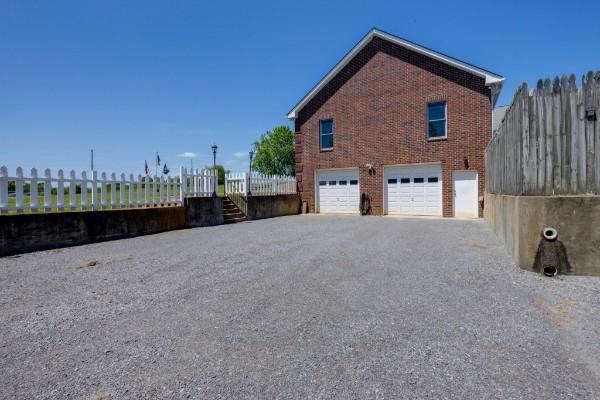 view of side of home featuring brick siding, driveway, and an attached garage