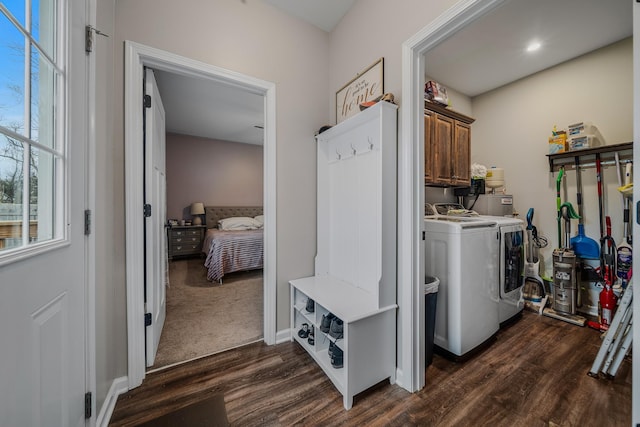 laundry room featuring cabinet space, baseboards, washer and clothes dryer, and dark wood finished floors