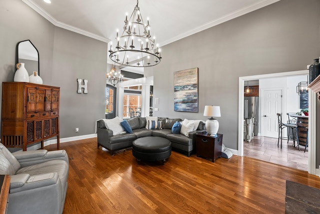 living area with a chandelier, dark wood-style flooring, ornamental molding, and a high ceiling