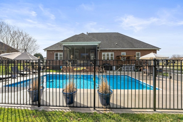 view of swimming pool featuring a sunroom, a patio, fence, and a fenced in pool