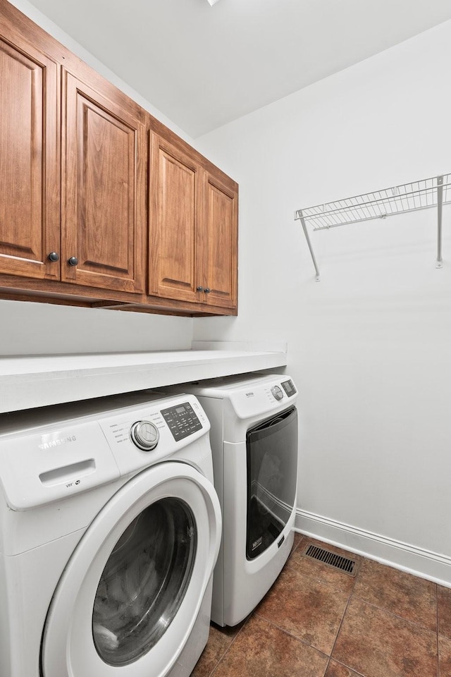 laundry room featuring visible vents, cabinet space, washer and clothes dryer, and baseboards