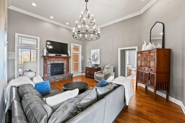 living room featuring a stone fireplace, recessed lighting, wood finished floors, baseboards, and ornamental molding