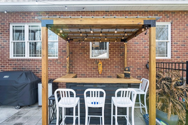 view of patio / terrace with a grill, outdoor dry bar, and fence