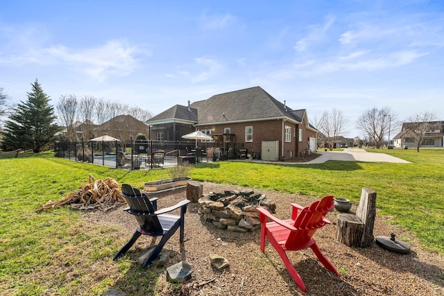 rear view of property with a fenced in pool, brick siding, a yard, a patio, and fence