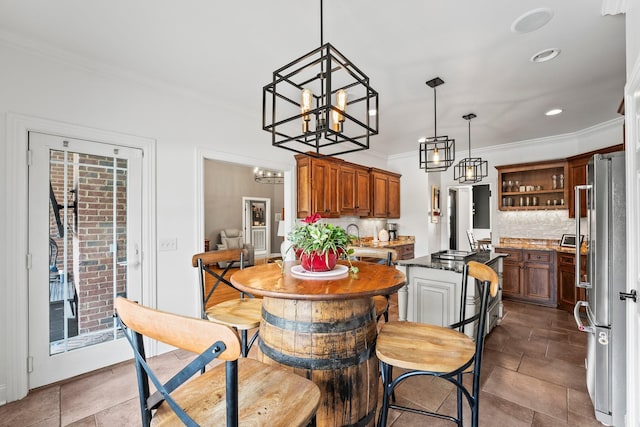 kitchen with brown cabinetry, decorative backsplash, freestanding refrigerator, open shelves, and a notable chandelier