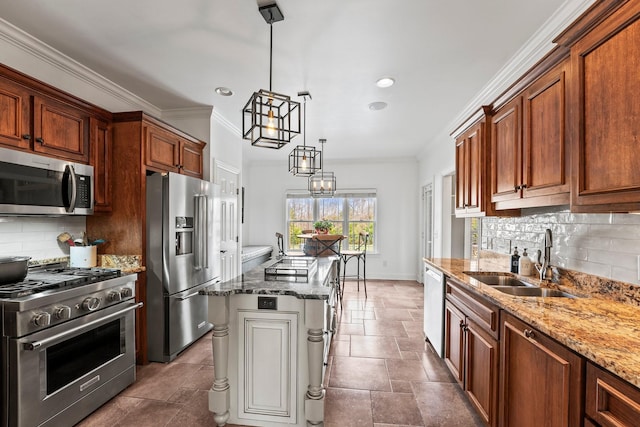 kitchen with a sink, brown cabinetry, pendant lighting, and premium appliances