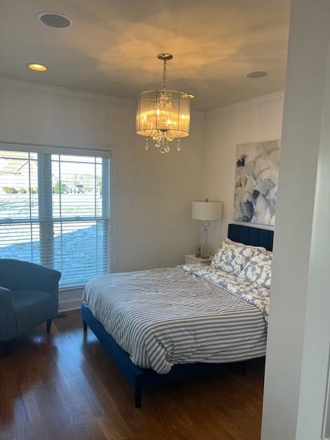 bedroom with crown molding, dark wood finished floors, a notable chandelier, and recessed lighting