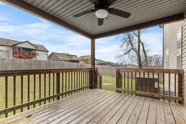 wooden terrace with a ceiling fan, a fenced backyard, and a yard