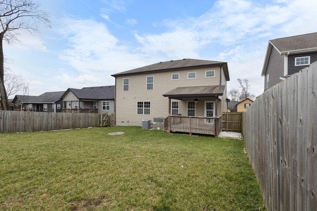 back of property featuring a yard, a fenced backyard, central AC, and a wooden deck