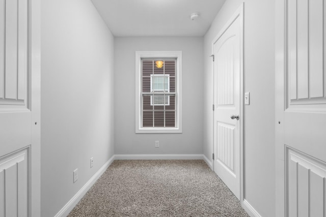 spare room featuring carpet and baseboards