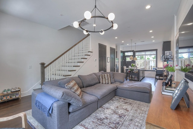 living area featuring stairway, wood finished floors, baseboards, an inviting chandelier, and recessed lighting