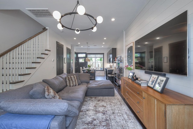 living room with a notable chandelier, visible vents, recessed lighting, and stairs