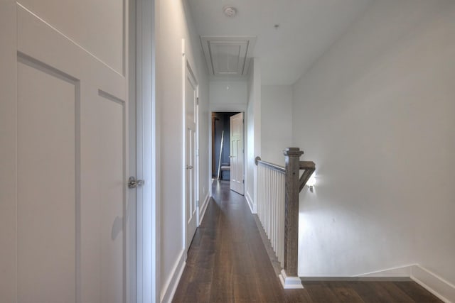 hallway with baseboards, attic access, an upstairs landing, and dark wood-style flooring