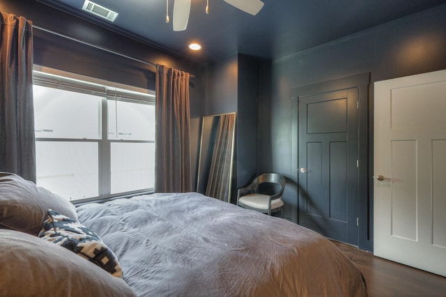 bedroom with visible vents, a ceiling fan, and wood finished floors