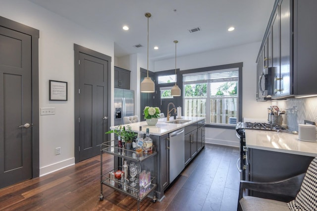 kitchen featuring visible vents, stainless steel appliances, a sink, light countertops, and backsplash