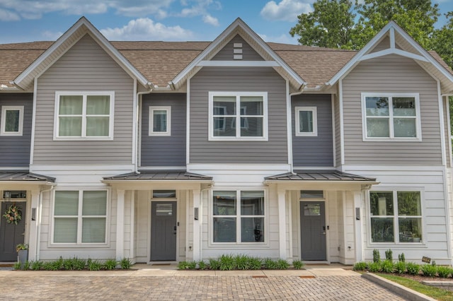 townhome / multi-family property with metal roof, a shingled roof, and a standing seam roof